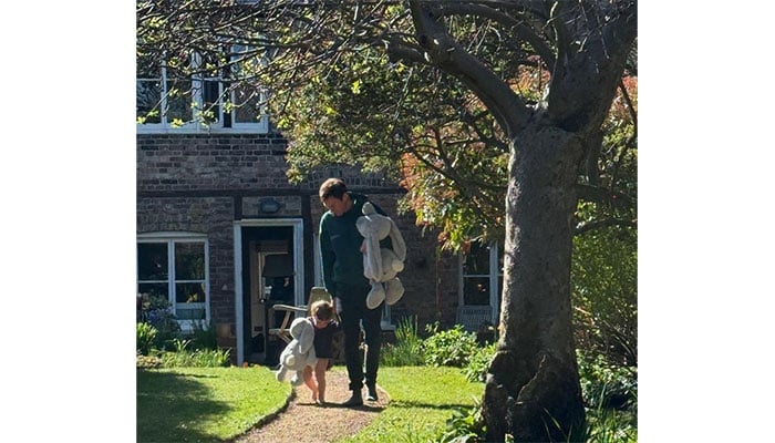 Jack and little Ernest are barefoot and each carrying an oversized toy bunny.