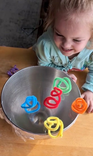 The goal is for the kids to try to move the pipe cleaners with their voice, as shown by Harter’s child at the bowl and watching the pipe cleaners fall off.