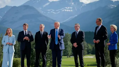 Chip Somodevilla/Getty Images World leaders gather at the G7 summit in Canada. Italian Prime Minister Giorgia Meloni, French President Emmanuel Macron, Canadian Prime Minister Mark Carney, U.S. President Donald Trump, British Prime Minister Keir Starmer, German Chancellor Friedrich Merz, and European Union Commission President Ursula von der Leyen are pictured in front of mountains.